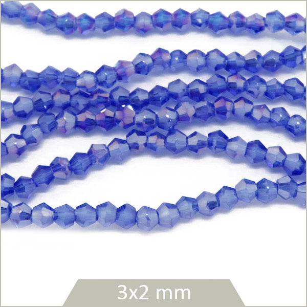 Env. 135 perles de verre toupies bleu irisé, 3x2 mm