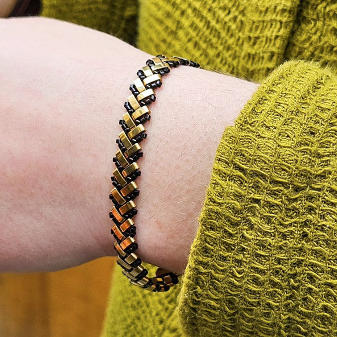 Env. 190 perles demi Tila en hématite doré