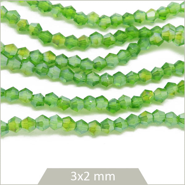 Env. 135 perles de verre toupies vert irisé, 3x2 mm