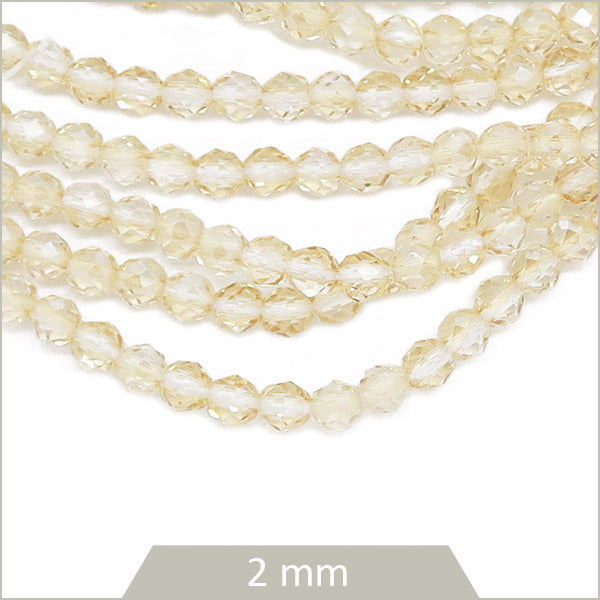 Env. 180 perles de verre à facettes beige transparentes, 2 mm
