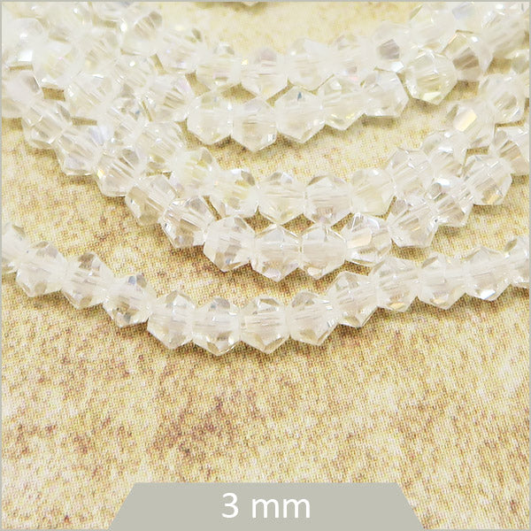 Env. 135 perles de verre toupies blanc irisé, 3 mm